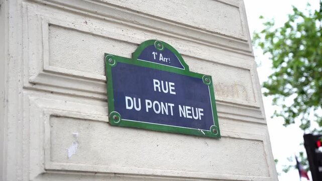 Close up shot of an iconic blue and green metal street sign for Rue du Pont Neuf in the 1st arrondissement of Paris, France. Highlights traditional Parisian urban design and typography.