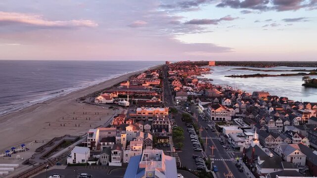 A view of downtown Sea Bright, New Jersey at sunset showing Route 36 (Ocean Avenue). Islands in a bay near Shrewsbury River are visible, as is the Atlantic Ocean.