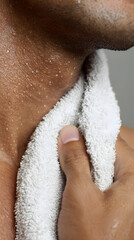 Fototapeta premium Close up of wet male neck and jawline with towel wiping droplets, intimate grooming moment conveying freshness and care