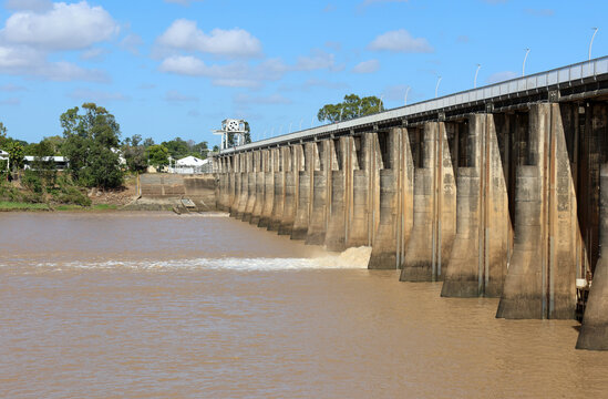 Fitzroy River Barrage releasing water into the muddy river under a blue sky in Rockhampton, Queensland, Australia