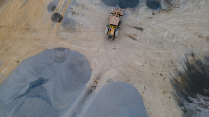 Wheel Dozer Carrying Crushed Stone to Outdoor Stockpile Area, Mining Site from Above © katakaneh