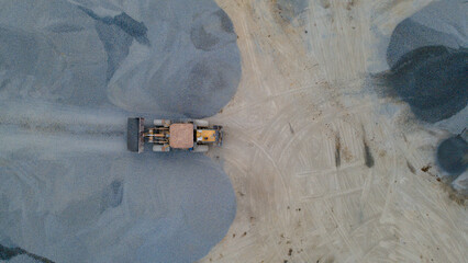 Wheel Dozer Carrying Crushed Stone to Outdoor Stockpile Area, Mining Site from Above © katakaneh