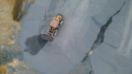 Wheel Dozer Carrying Crushed Stone to Outdoor Stockpile Area, Mining Site from Above © katakaneh