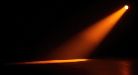 Fototapeta premium A vibrant orange spotlight cuts through a pitch black background, creating dramatic cinematic god rays across an empty theater stage floor, energy, mystery, concert