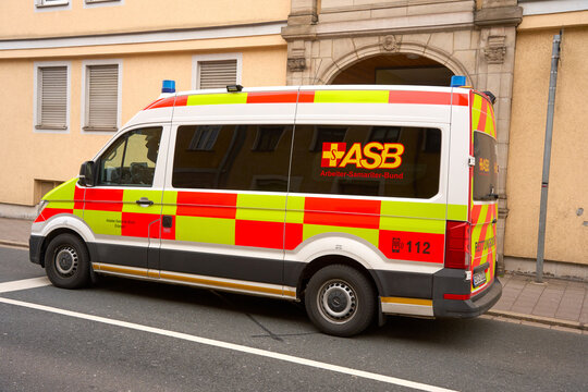 German ASB ambulance vehicle parked on a city street in front of a historic building.