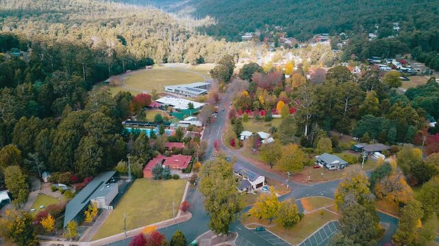 Cinematic 4K drone footage capturing Marysville town, tree lined roads, residential homes, and vibrant autumn foliage beneath clear afternoon skies.