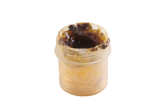 Small container holds dark, thick substance