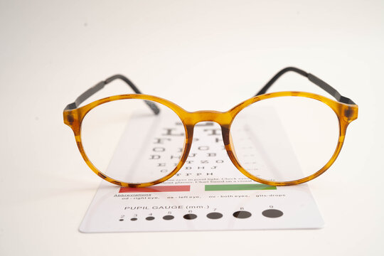 Glasses on eye testing exam chart to check eyesight accuracy of reading.