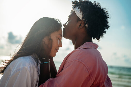 Happy interracial couple embracing and sharing a romantic moment during a tropical island getaway