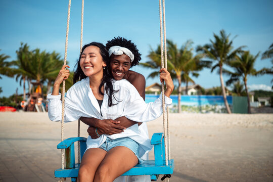 Carefree couple enjoying a tropical beach vacation, laughing making unforgettable memories together