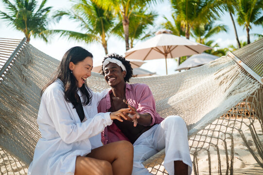 Carefree couple enjoying a tropical beach vacation, laughing making unforgettable memories together