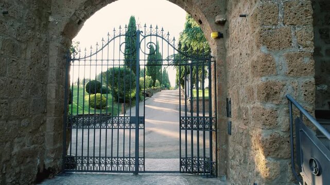 Italian villa featuring wrought iron gates and scenic driveway