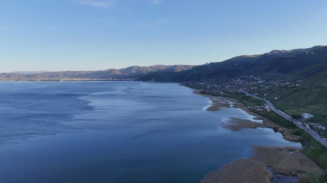 Pogradec city at the distance in the lin vilage view with ohrid lake aerial view zoom out