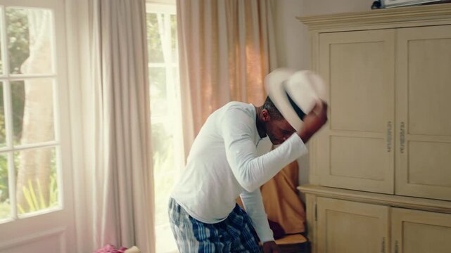 Dancing, hip hop and black man in home with hat for celebration, performance or practice. Happy, movement and male person with expression for rhythm hobby, entertainment and morning fun in pyjamas