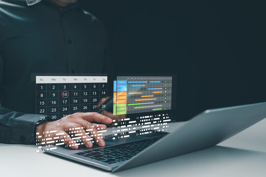 Male boss plans work tasks inside dark room, typing computer keys near virtual calendar chart overlay screen, tracking project timeline progress, managing main agenda daily, scheduling team plan.