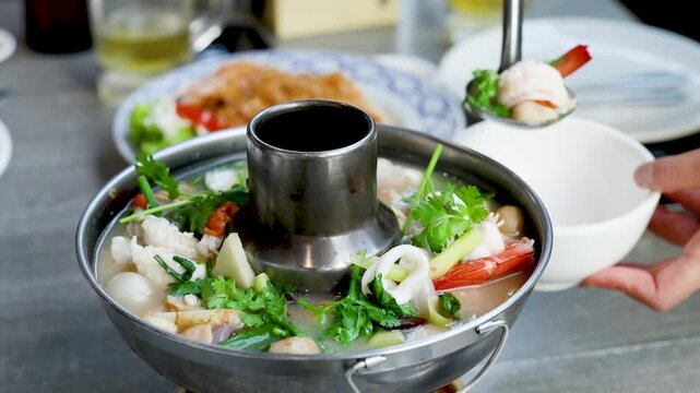 Serving Fresh Thai Seafood Hot Pot Tom Yum Soup in Restaurant