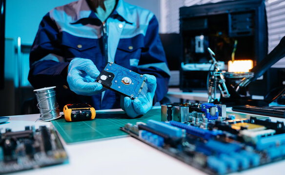 Technician repairing inside of hard disk drive by screwdriver. the concept of data, hardware, technician and technology. computer hardware, repairing, upgrade