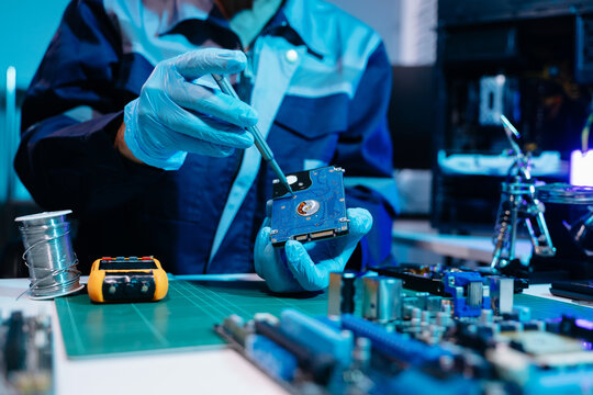 Technician repairing inside of hard disk drive by screwdriver. the concept of data, hardware, technician and technology. computer hardware, repairing, upgrade