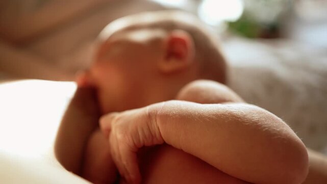 Intimate close up showing a mother breastfeeding her newborn baby, highlighting the natural bond and nurturing connection. The infant latches and suckles while the mother tenderly caresses