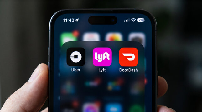 Uber, Lyft, and DoorDash mobile icons app on a screen smartphone iPhone. Uber and Lyft are ridesharing services, while DoorDash is a popular food delivery platform in the gig economy services.