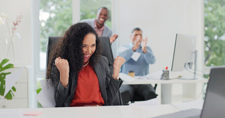 Fototapeta premium Excited, woman and fist pump in office with laptop, investment approval or team clapping for success. Happy, person and celebration in business with computer, funding offer and coworkers applause.