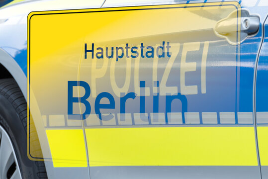 Ortstafel Berlin und Einsatzwagen der Berliner Polizei