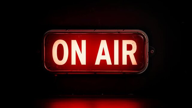Bright red on air sign glowing in dark studio for broadcasting and live streaming concept
