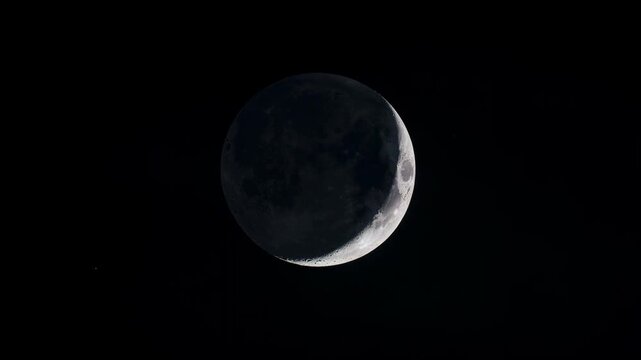 Detailed crescent moon in dark night sky with visible craters and shadows