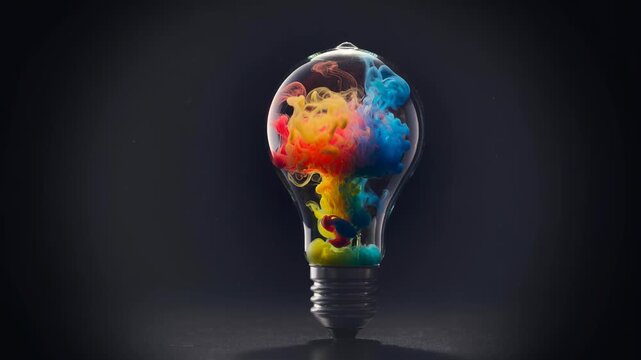 Creative colorful smoke inside a light bulb symbolizing innovation and bright ideas on dark background