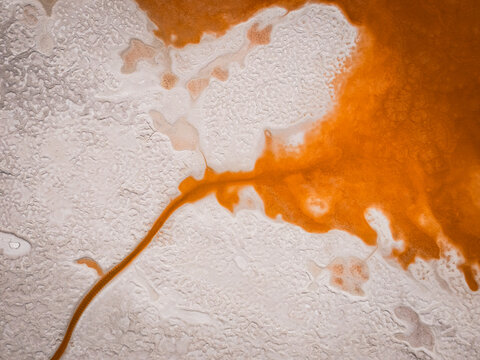 An orange river snakes across a white landscape