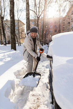 Man shoveling deep snow from his car