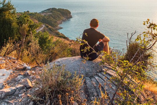 Traveler sitting on coastal bunker above Pul&euml;bardha Beach in Albania