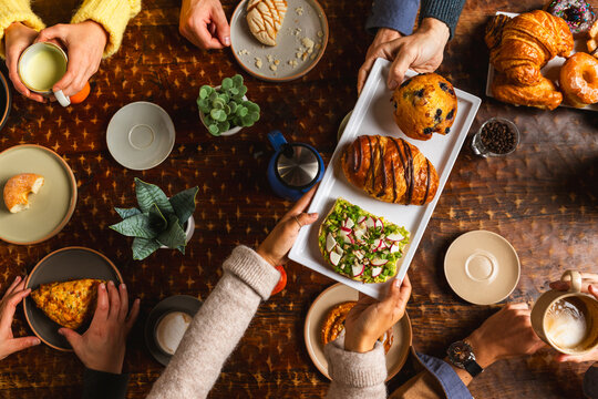 Friends sharing pastries and coffee at a table