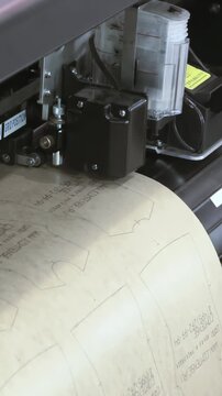 Witness industrial automation's grace as a sophisticated computer-driven system meticulously carves intricate garment patterns.