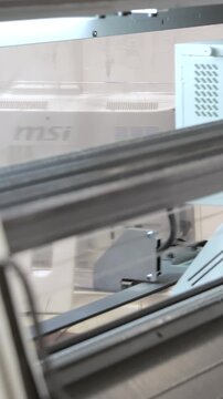 Observe advanced industrial computer equipment in a garment factory. The MSI system guides a precise mechanism, swiftly processing materials with automated efficiency.