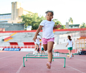 Obraz premium Portait of sports coach, children at stadium having althletics training. Portrait of athlete group, coaching and training at sport academy