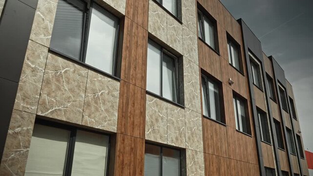 Contemporary Building Facade. Architectural Composition Featuring Textured Materials And Dramatic Sky Backdrop