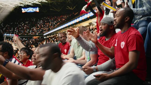 Tense sports fans checking online betting odds and cash out options on smartphone, live football match in the stadium stands, passionate supporters tracking risky wagers on betting apps.