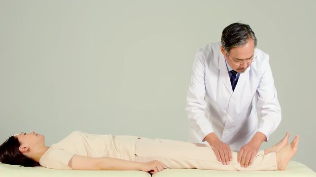 Elderly man massagist orthopedic physiotherapist helping women physical rehabilitation leg, hip treatment to female patient, doctor doing stretching disease treatment at diagnosis clinic hospital