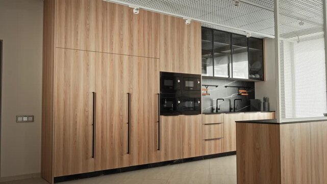 Urban Office Refreshment Area. Bright Shared Office Kitchen Featuring Stainless Appliances And Casual Seating