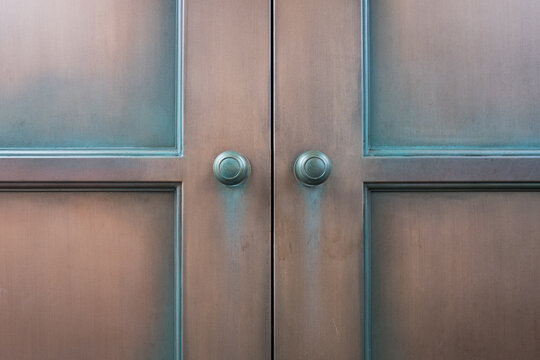 Double wooden door and old round brass knobs