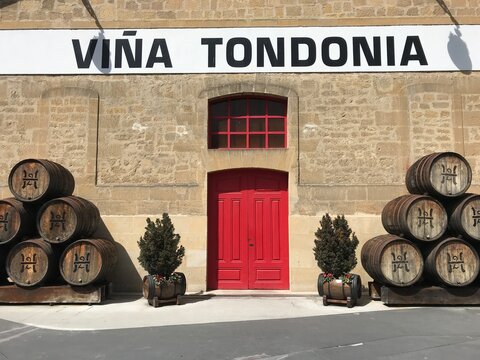 Traditional Spanish Winery Entrance with Red Doors and Oak Barrels