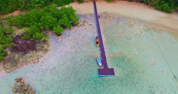 Aerial View of Exotic Beach Landscape in Phang Nga. Scenic drone panorama of a tropical coastline with crystal clear seawater and vibrant coral formations along Mai Ngam Beach, Thailand.