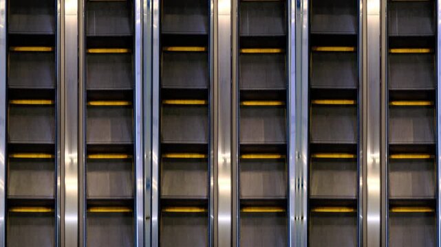 the steps of an empty escalator move up close up view from above