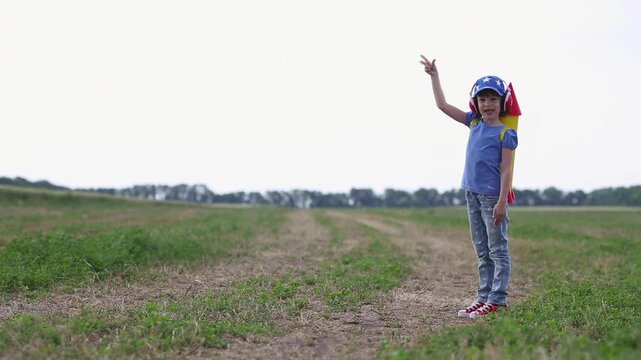 A happy child runs around the field with a toy jetpack