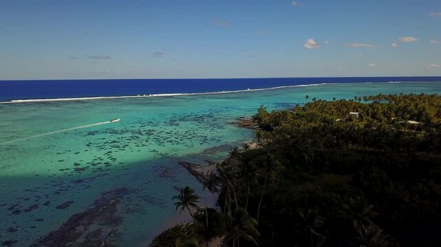 Aerial drone view of French Polynesia capturing turquoise lagoon waters, white sandy beaches and lush palm tree forests against green volcanic mountains. Islands Bora Bora, Huahine, Tahiti, Rangiroa