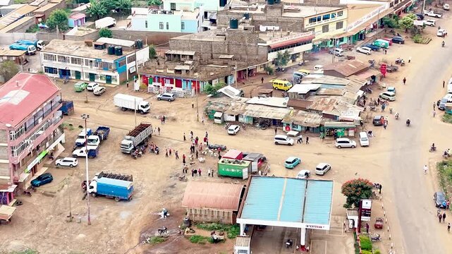 A cinematic view of rural Kenya showcasing informal settlements with rusted tin roofs, weathered homes, dusty village paths, and everyday community life.