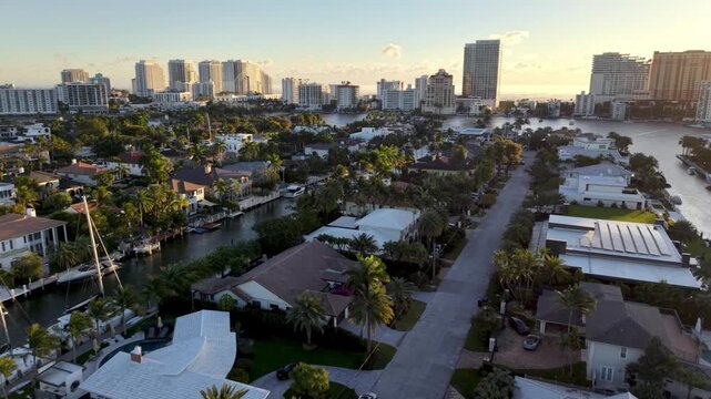 homes along canal in fort lauderdale florida aerial push in over real estate with skyline backdrop