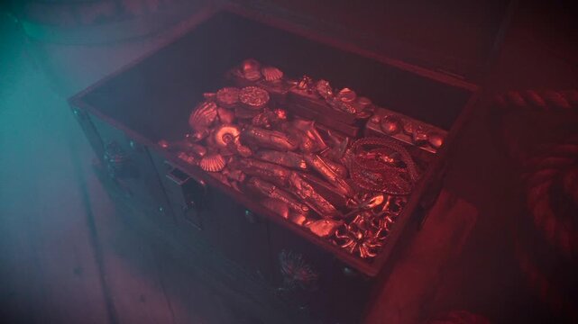 Gold filled treasure chest in foggy atmosphere at night.