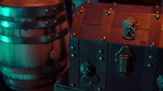 Torch light and water reflections play on a treasure chest and keg of grog.